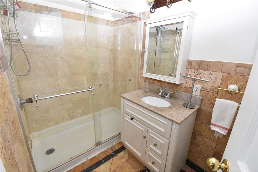 424 Grape Street Whitehall, PA 18052 - Photo 33 of 50 This bathroom features a contemporary vanity with a granite counter and a spacious glass-enclosed shower.