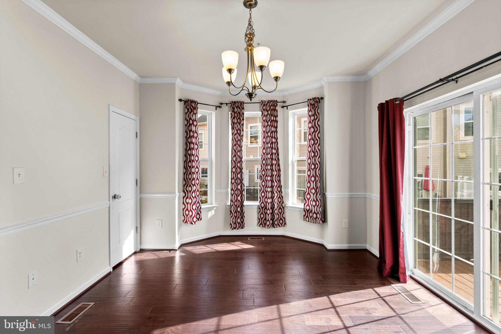 7977 Alchemy Way Elkridge, MD 21075 - Photo 11 of 33 a view of an empty room with window and chandelier