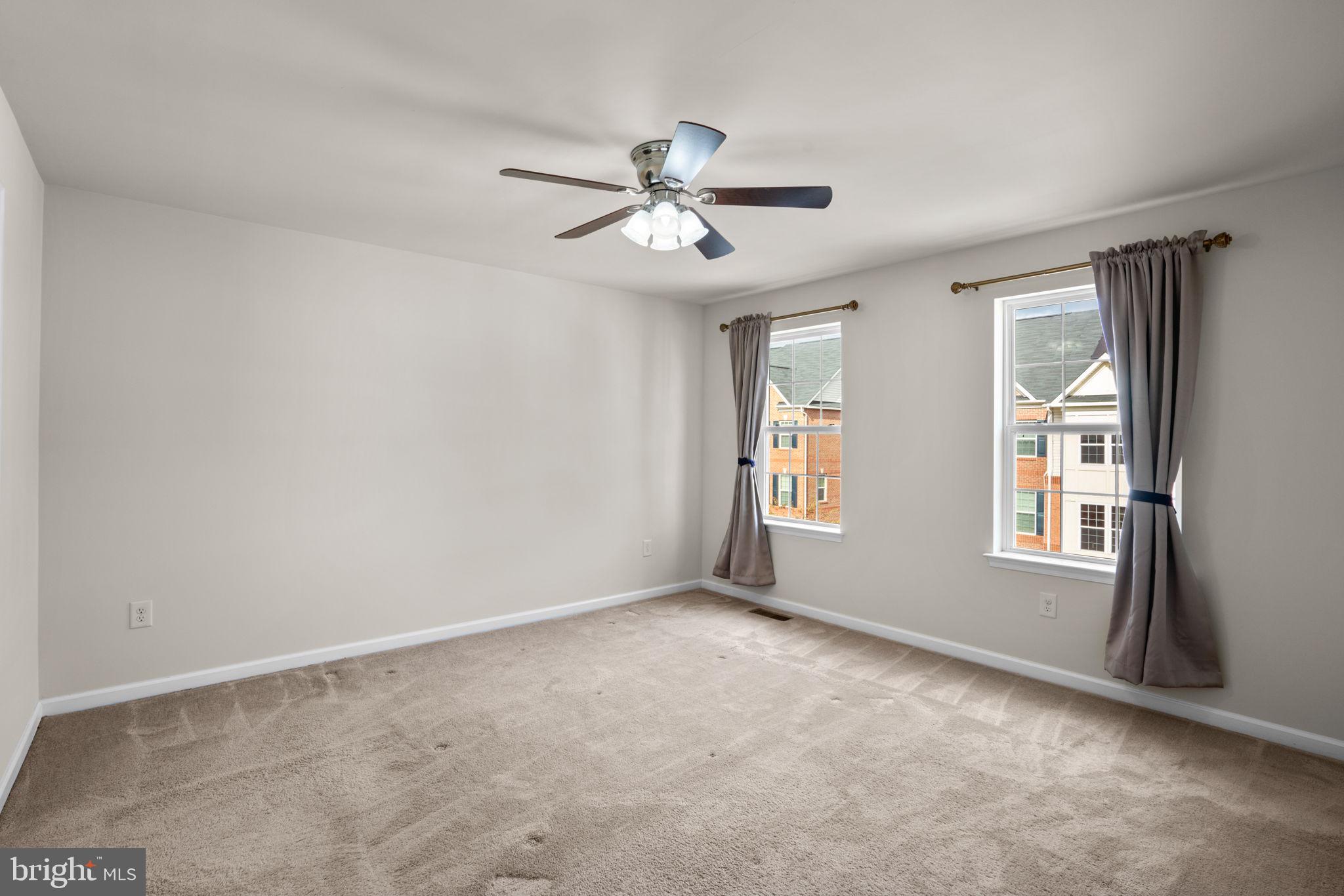 7977 Alchemy Way Elkridge, MD 21075 - Photo 16 of 33 an empty room with windows and fan