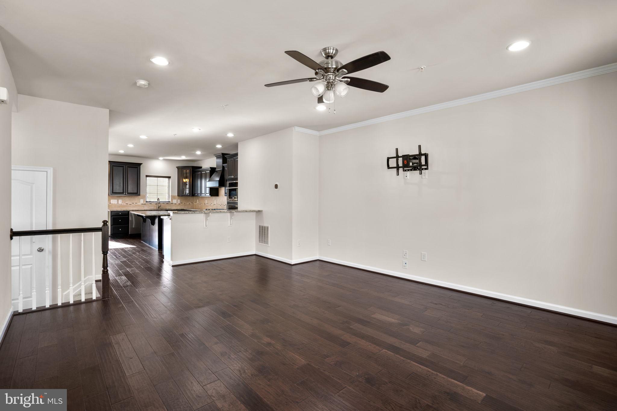 7977 Alchemy Way Elkridge, MD 21075 - Photo 2 of 33 a view of a big room with wooden floor and a kitchen