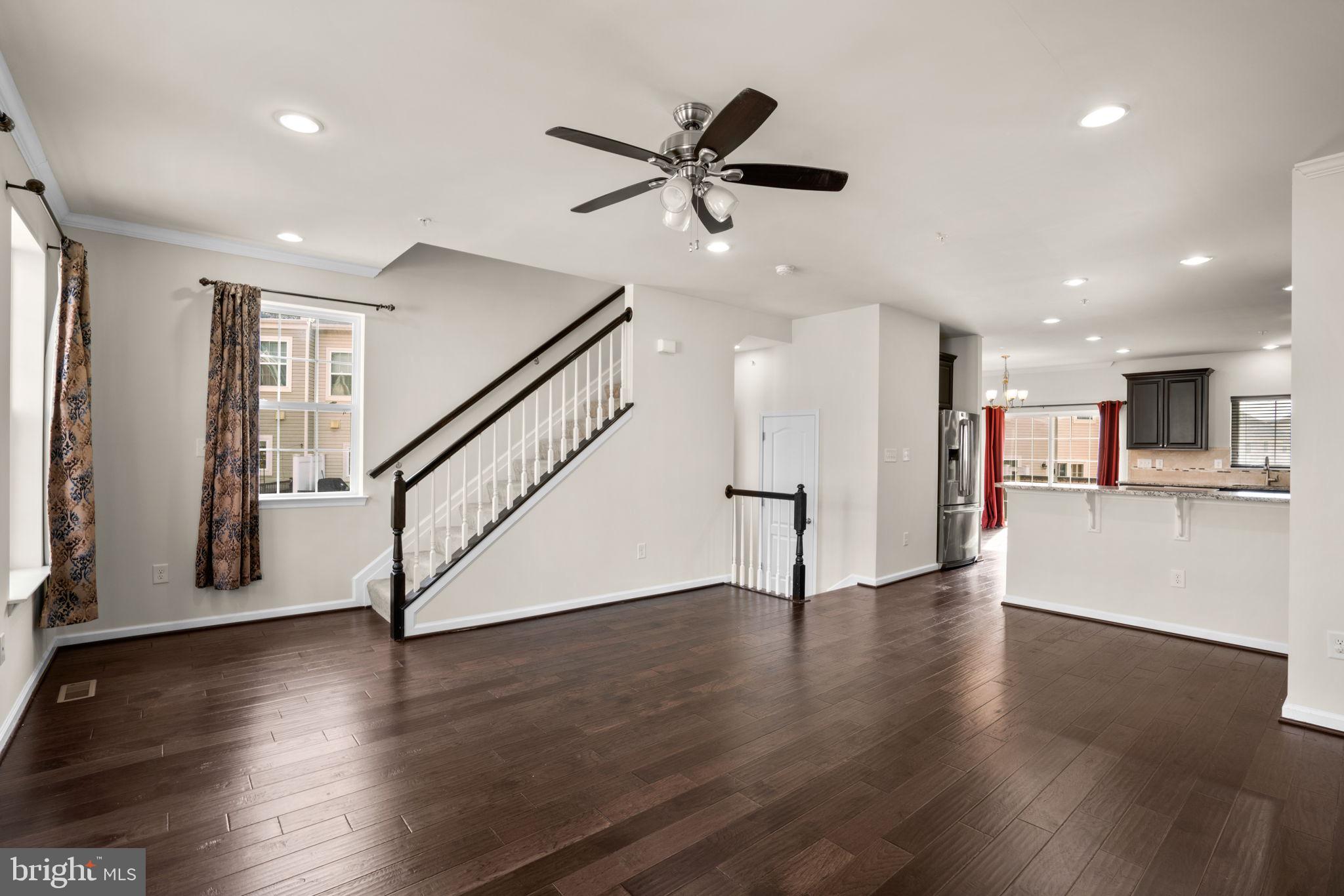 7977 Alchemy Way Elkridge, MD 21075 - Photo 5 of 33 a view of an empty room with wooden floor and a ceiling fan