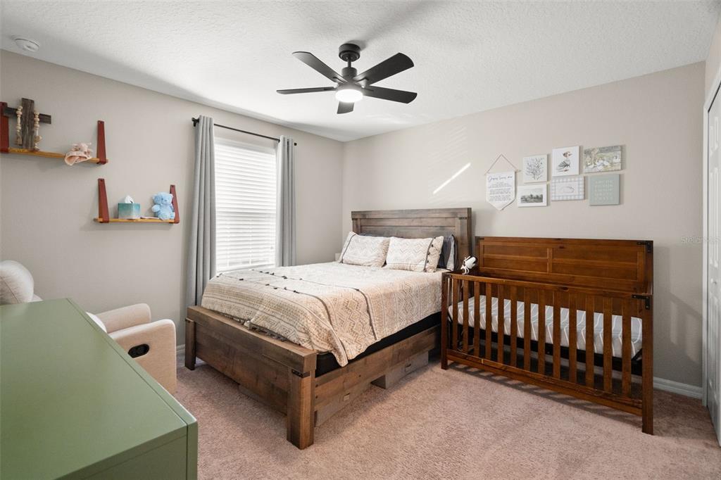 1216 Multiflora Loop Lutz, FL 33558 - Photo 27 of 50 a bedroom with a bed and a chandelier