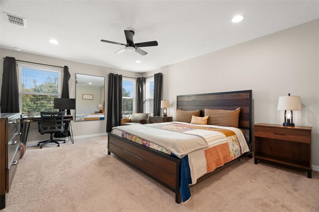 1216 Multiflora Loop Lutz, FL 33558 - Photo 30 of 50 a large bedroom with a bed a desk and chair