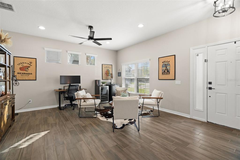1216 Multiflora Loop Lutz, FL 33558 - Photo 3 of 50 a living room with couches a computer on desk and wooden floor