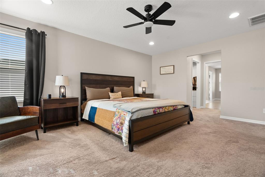 1216 Multiflora Loop Lutz, FL 33558 - Photo 31 of 50 a bed sitting in a spacious bedroom next to a window