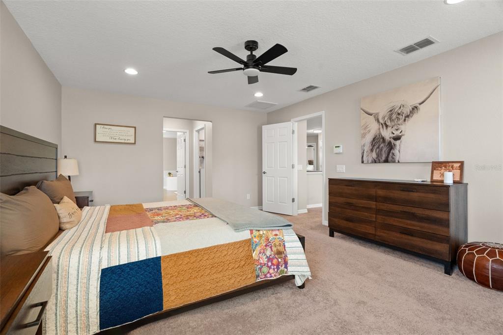 1216 Multiflora Loop Lutz, FL 33558 - Photo 32 of 50 a bedroom with a bed and a chandelier