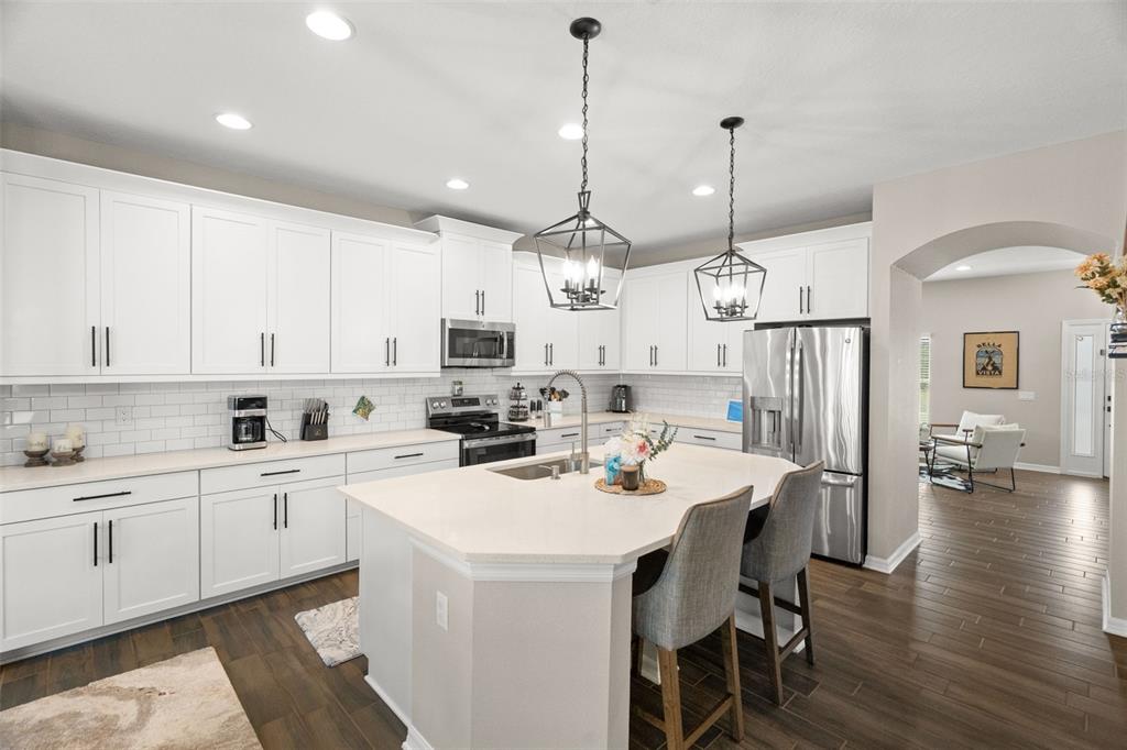 1216 Multiflora Loop Lutz, FL 33558 - Photo 7 of 50 a kitchen with a sink a center island and cabinets