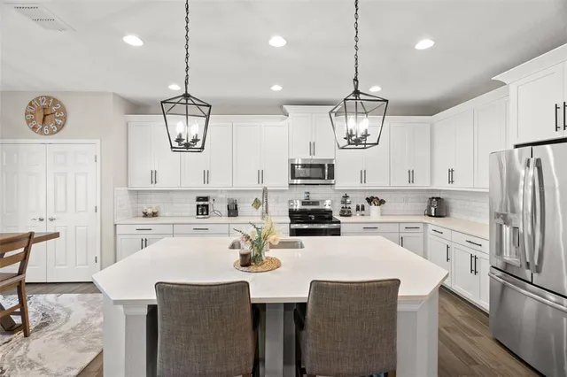 a kitchen with refrigerator cabinets dining table and chairs