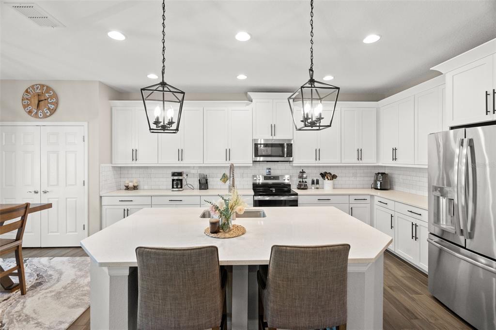 1216 Multiflora Loop Lutz, FL 33558 - Photo 8 of 50 a kitchen with refrigerator cabinets dining table and chairs