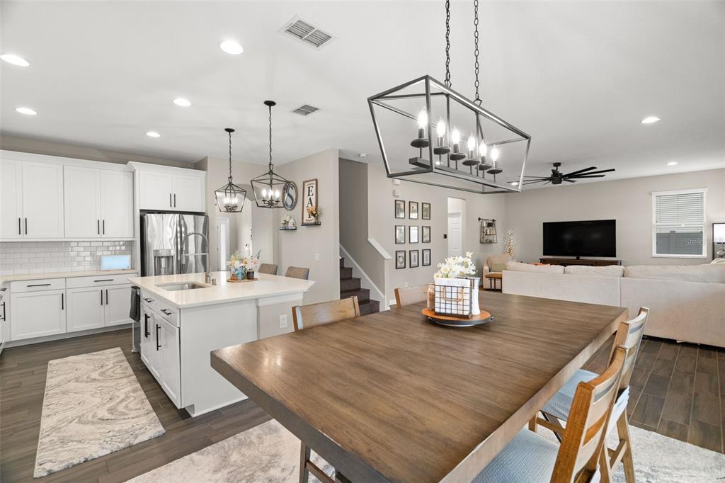 1216 Multiflora Loop Lutz, FL 33558 - Photo 10 of 50 a kitchen with stainless steel appliances granite countertop a kitchen island a stove a table a sink and a flat screen tv