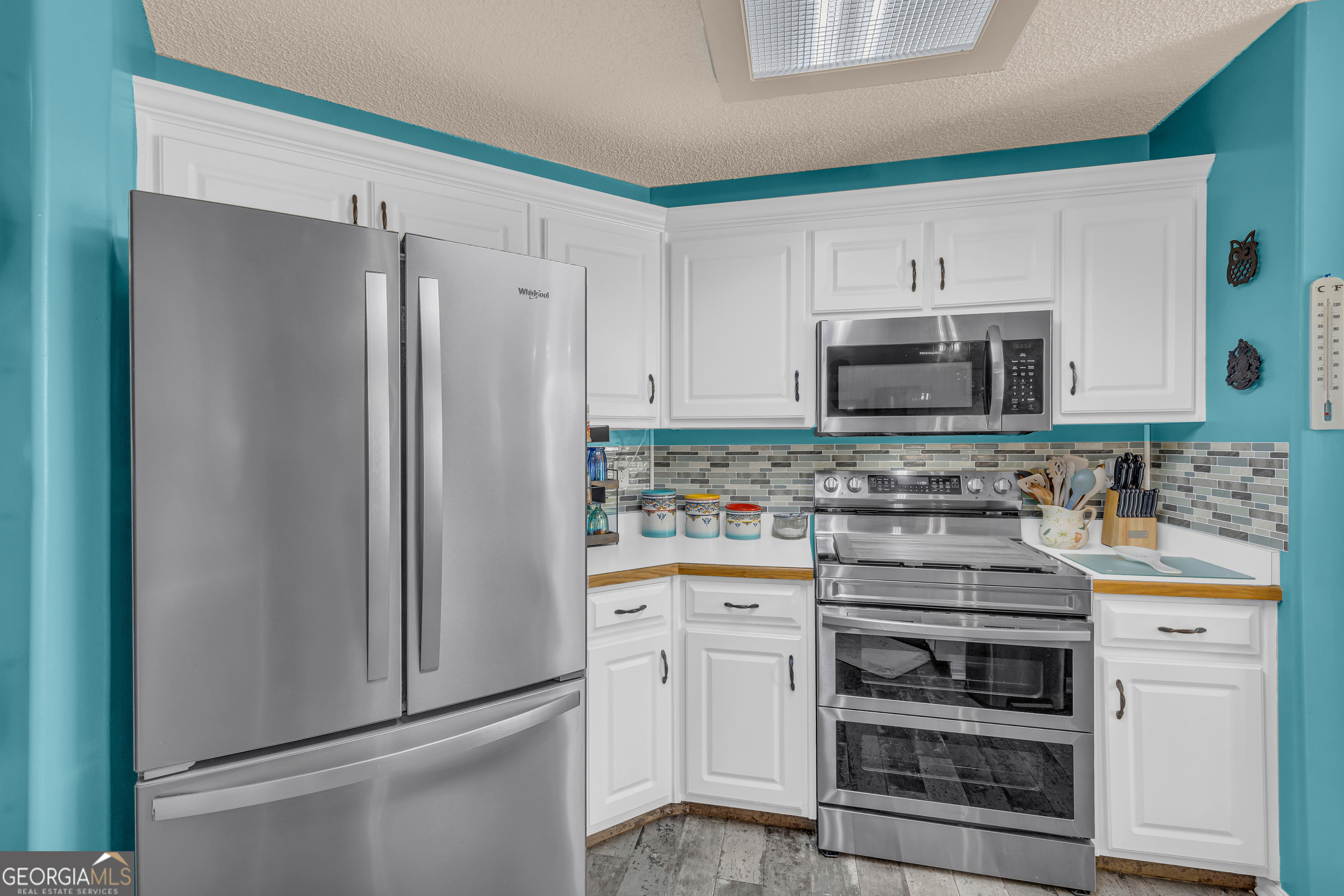 139 Silverstone Circle Jefferson, GA 30549 - Photo 45 of 85 a kitchen with white cabinets and stainless steel appliances
