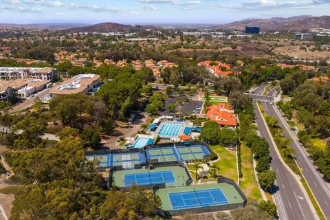 an aerial view of residential houses with outdoor space and trees