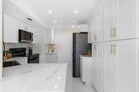 a kitchen with stainless steel appliances a refrigerator and a stove top oven