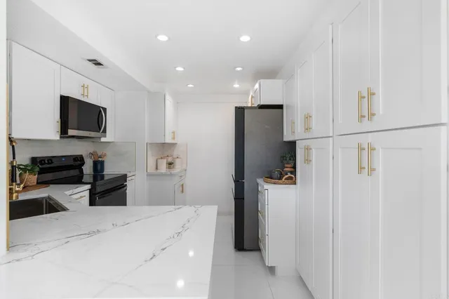 a kitchen with stainless steel appliances a refrigerator and a stove top oven