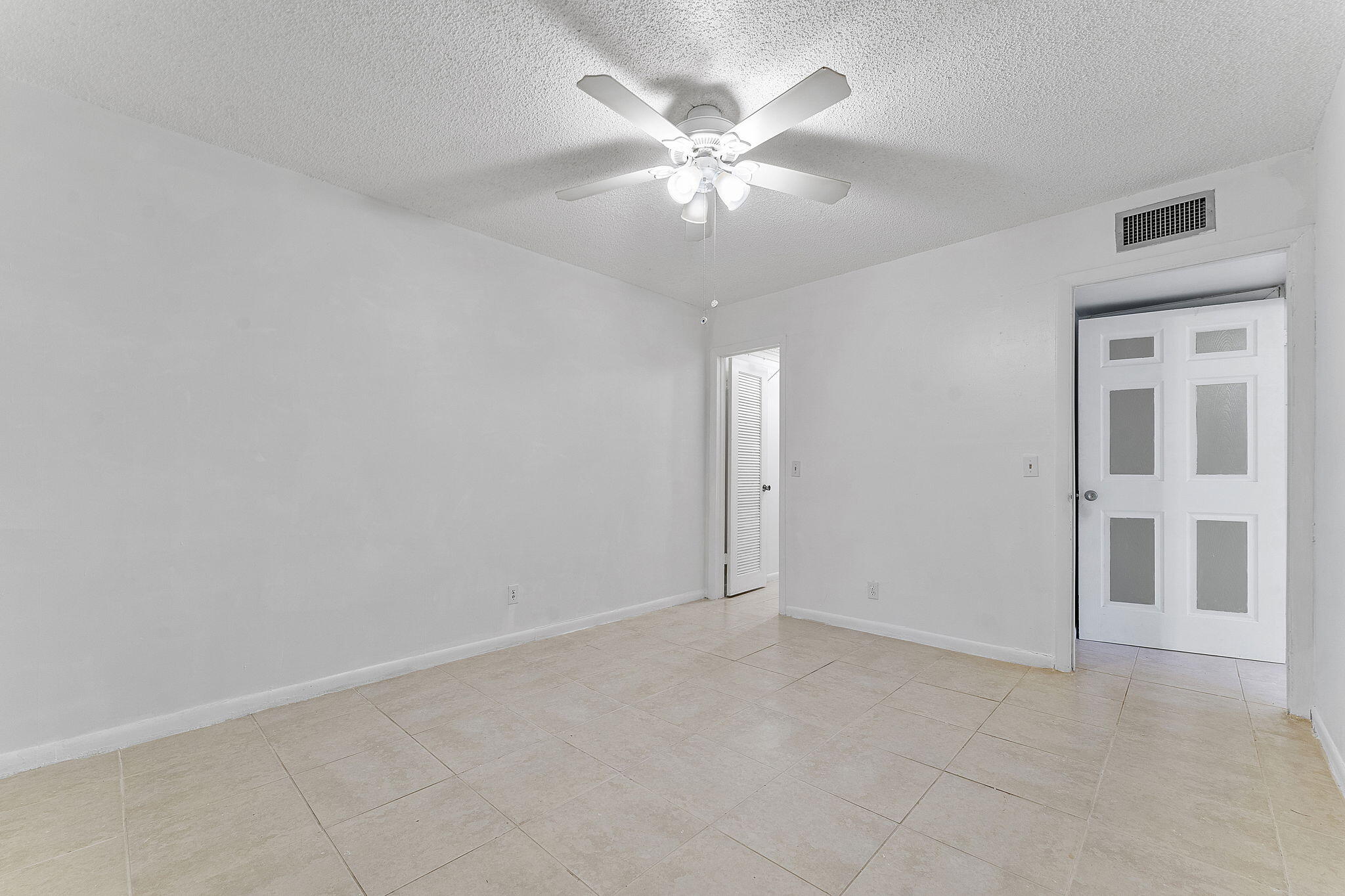 877 Flanders South Delray Beach, FL 33484 - Photo 23 of 27 an empty room with chandelier fan and windows