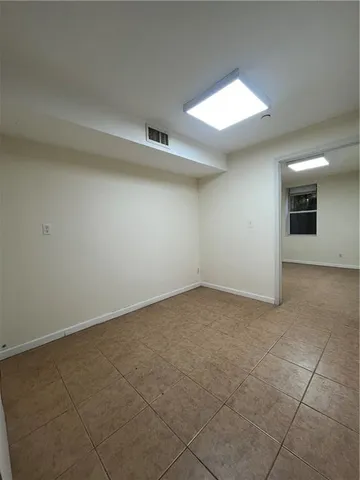 a view of a room with an empty space and a window