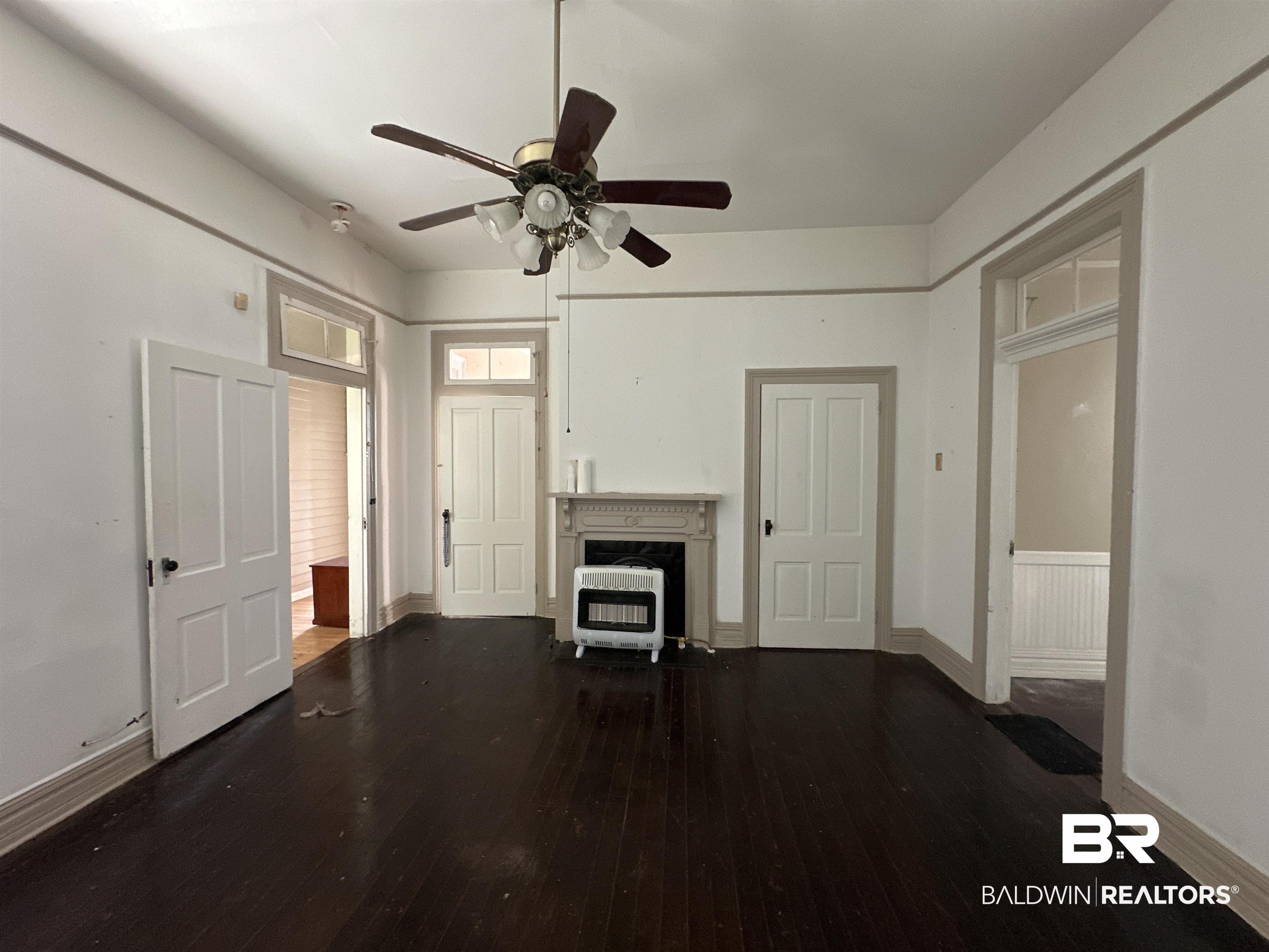 1119 Old Shell Road Mobile, AL 36604 - Photo 9 of 22 Unfurnished living room featuring ceiling fan, a high end fireplace, dark hardwood / wood-style flooring, and heating unit