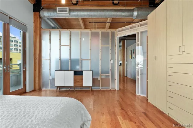 a bedroom with a bed and wooden floor