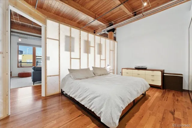 a bedroom with a bed and a large window