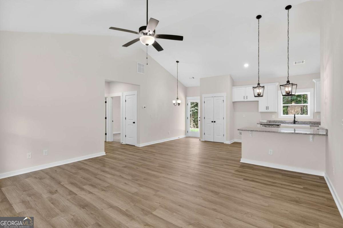 1081 Drummond Road Cedartown, GA 30125 - Photo 13 of 67 a view of a kitchen with kitchen island a sink wooden floor and a ceiling fan