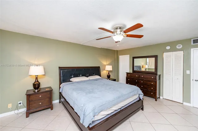 a bedroom with a bed and a lamp on dresser