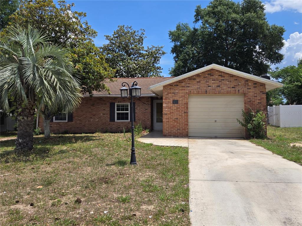 19 Spring Dr Place Ocala, FL 34472 - Photo 2 of 29 a front view of a house with a yard and garage
