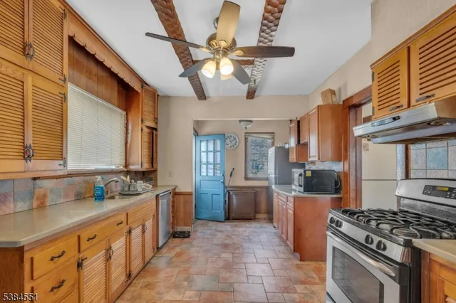 a kitchen with stainless steel appliances granite countertop a sink a stove and a refrigerator