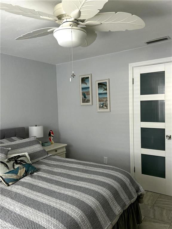 13511 Island Road Fort Myers, FL 33905 - Photo 25 of 38 a bedroom with a bed and a chandelier