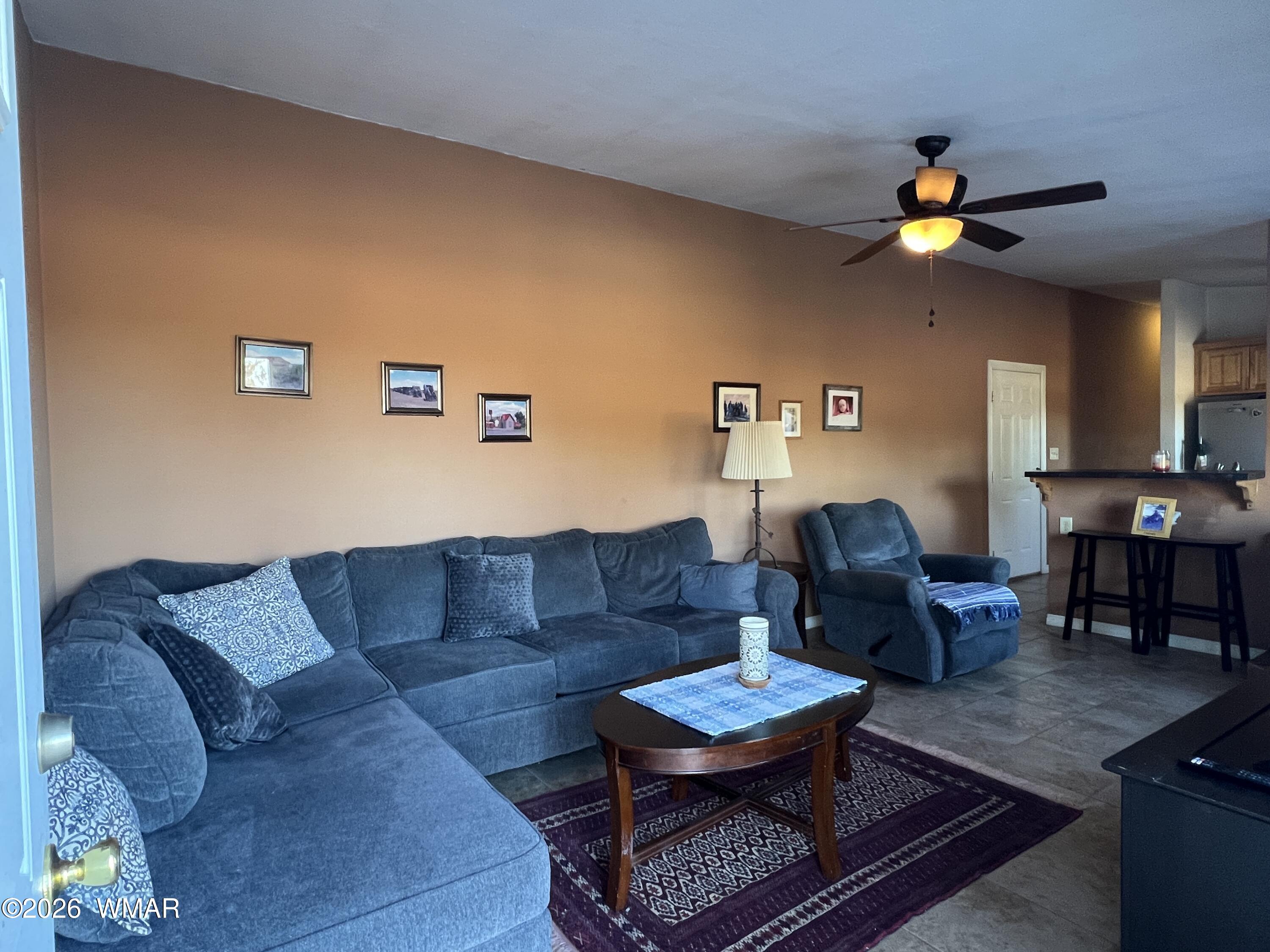 25 North County Road St. Johns, AZ 85936 - Photo 10 of 55 a living room with couches a coffee table and a piano with wooden floor