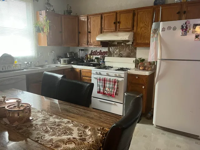 a kitchen with stainless steel appliances granite countertop a stove a sink and a refrigerator