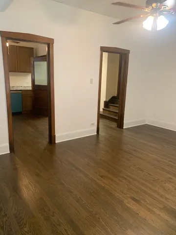 an empty room with wooden floor and mirror