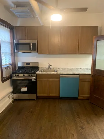 a kitchen with stainless steel appliances kitchen island granite countertop a stove a sink and a microwave