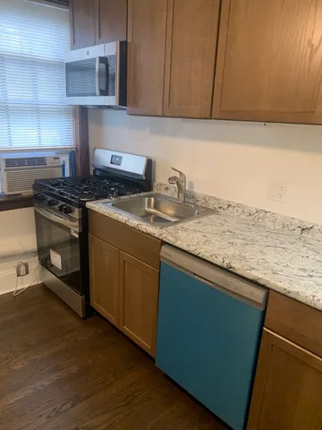 a kitchen with granite countertop wood cabinets and a stove top oven