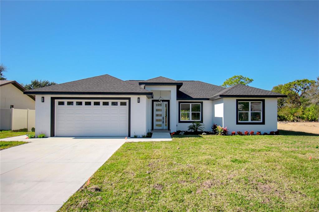 a front view of a house with a garden and yard
