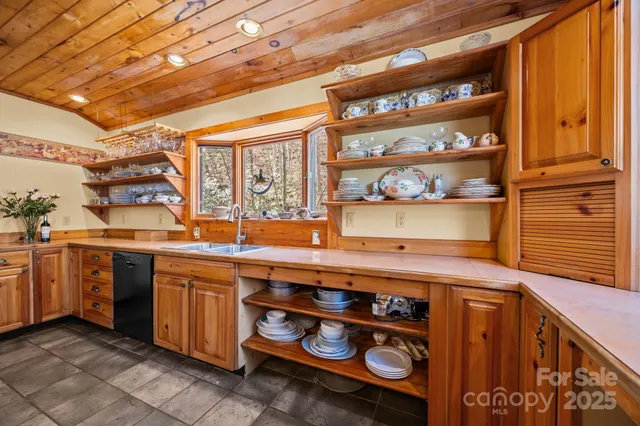 a kitchen with stainless steel appliances kitchen island granite countertop a table chairs and a refrigerator