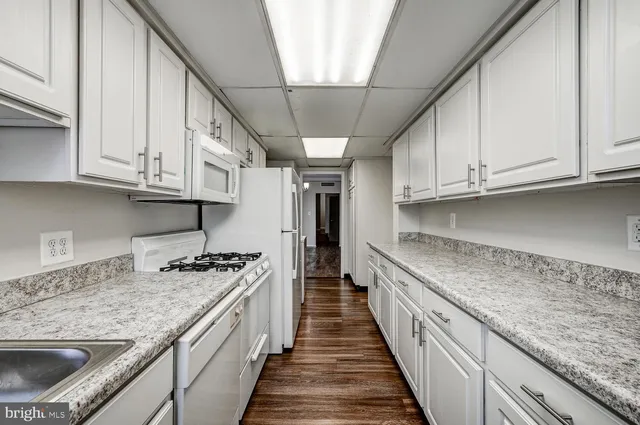 a kitchen with granite countertop a sink stove and cabinets