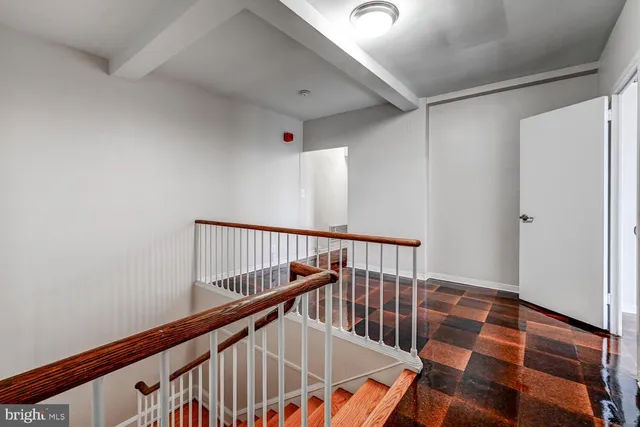 a view of staircase with railing and white walls
