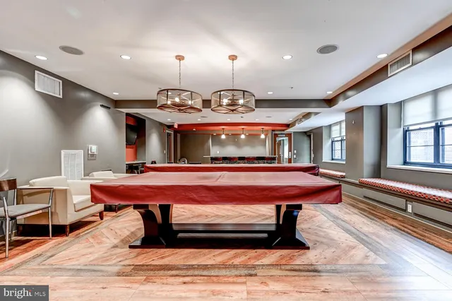 a living room with a table tennis pool table and chairs