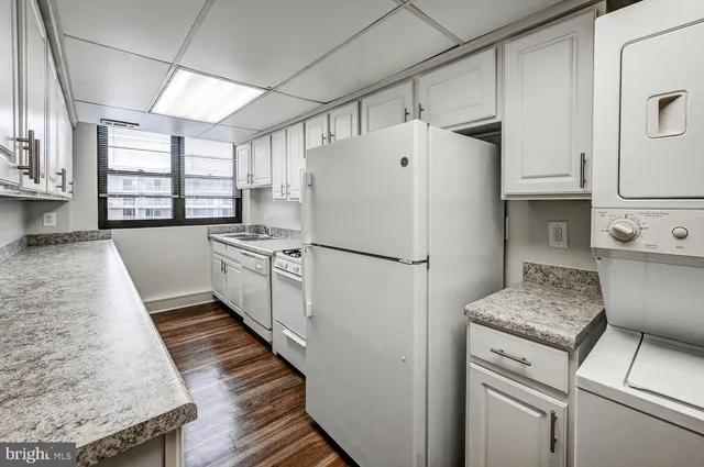 a kitchen with kitchen island a counter top space a sink stainless steel appliances and cabinets