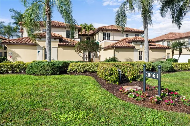 a view of a house with a big yard and palm trees