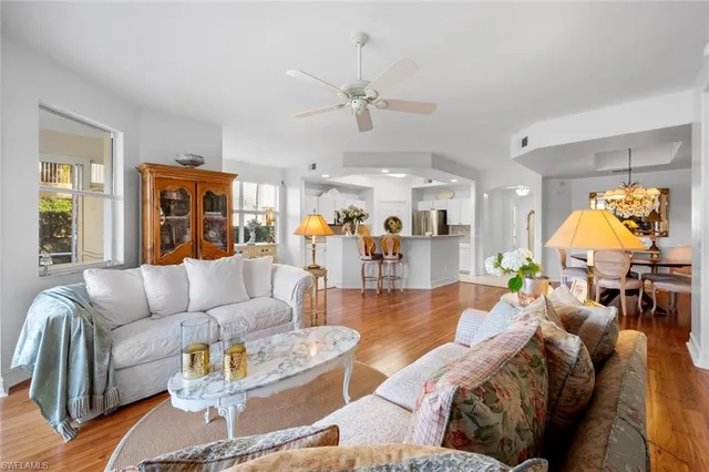 a living room with furniture kitchen view and a large window