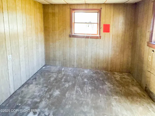 a view of an empty room with window and a door
