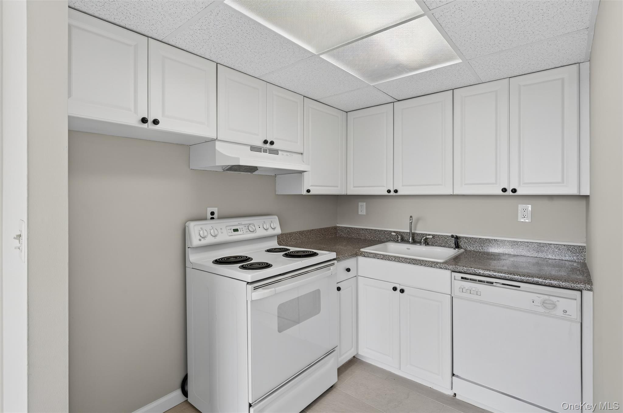 150 Overlook Avenue, Unit 7F Peekskill, NY 10566 - Photo 9 of 24 a kitchen with granite countertop white cabinets and white appliances
