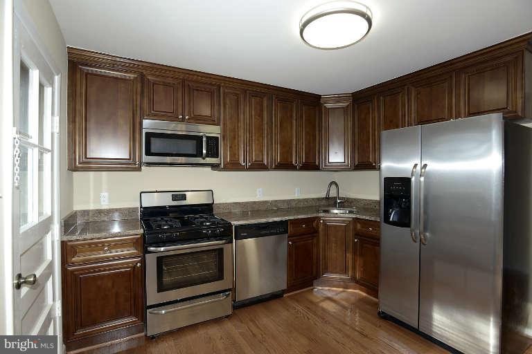 3816 Littleton Street Silver Spring, MD 20906 - Photo 2 of 21 a kitchen with granite countertop stainless steel appliances and wooden cabinets