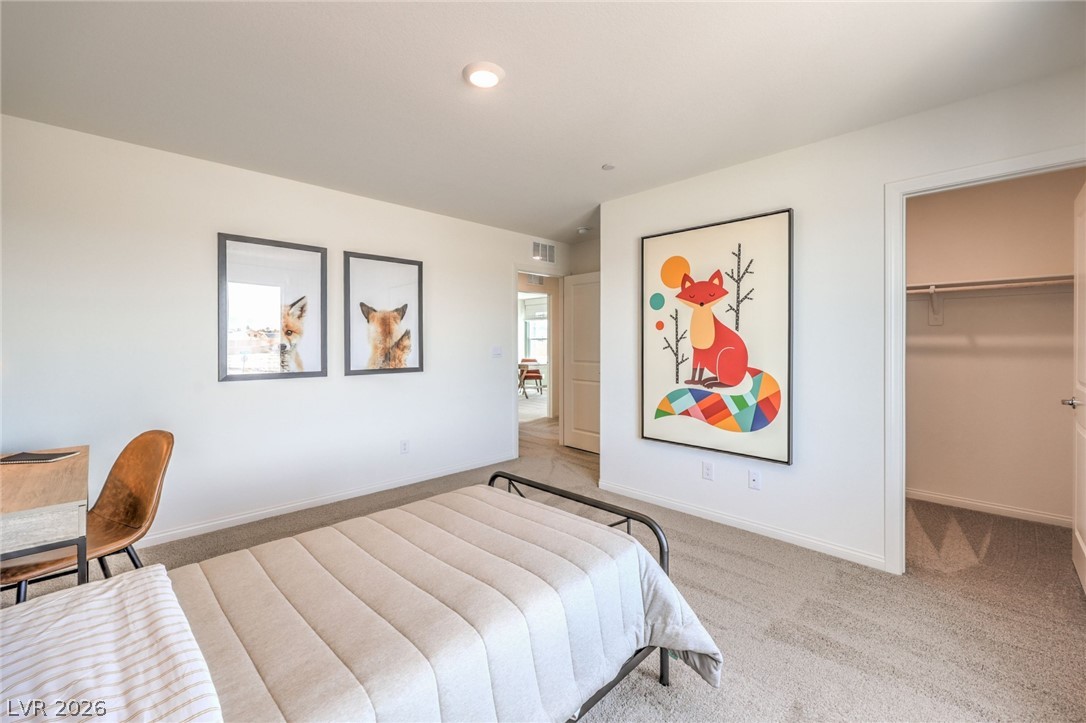 1017 Copper Robin Street Henderson, NV 89011 - Photo 29 of 43 Bedroom with light carpet, a walk in closet, baseboards, and recessed lighting. Photo is representational only; actual home finishes may vary.