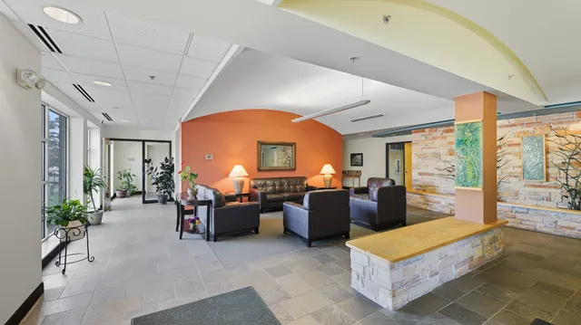 a living room with furniture gym equipment and large windows