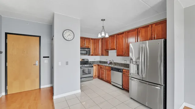 a kitchen with stainless steel appliances granite countertop a refrigerator a oven a sink and a refrigerator