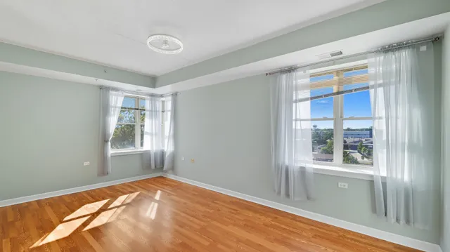 a view of a bedroom with wooden floor and windows