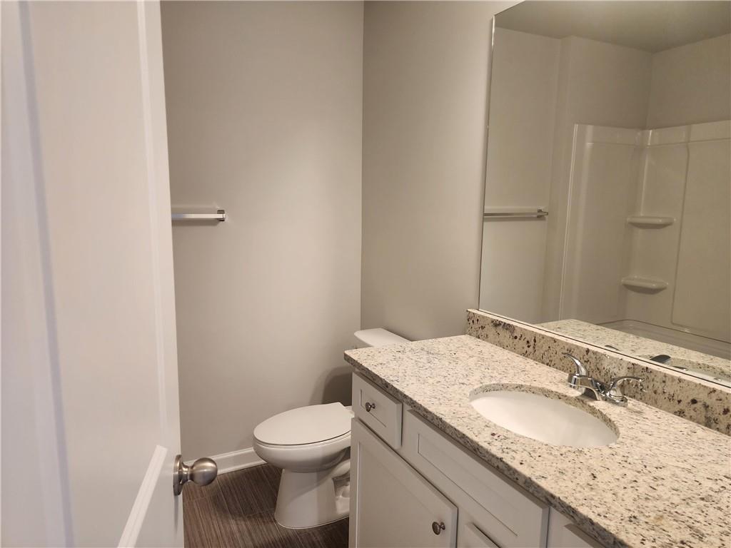 832 Cygnet Lane Grayson, GA 30017 - Photo 29 of 35 a bathroom with a granite countertop sink a toilet and a mirror