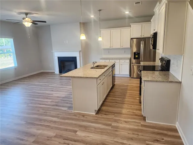 a kitchen with stainless steel appliances granite countertop a sink stove and refrigerator